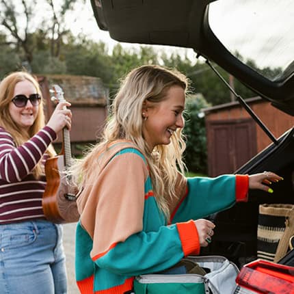 Two people packing items into a car