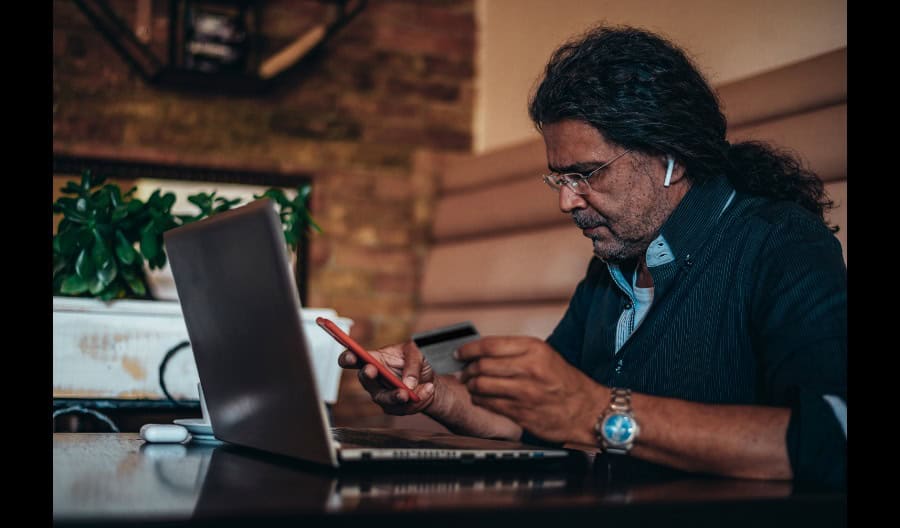man using mobile phone and laptop